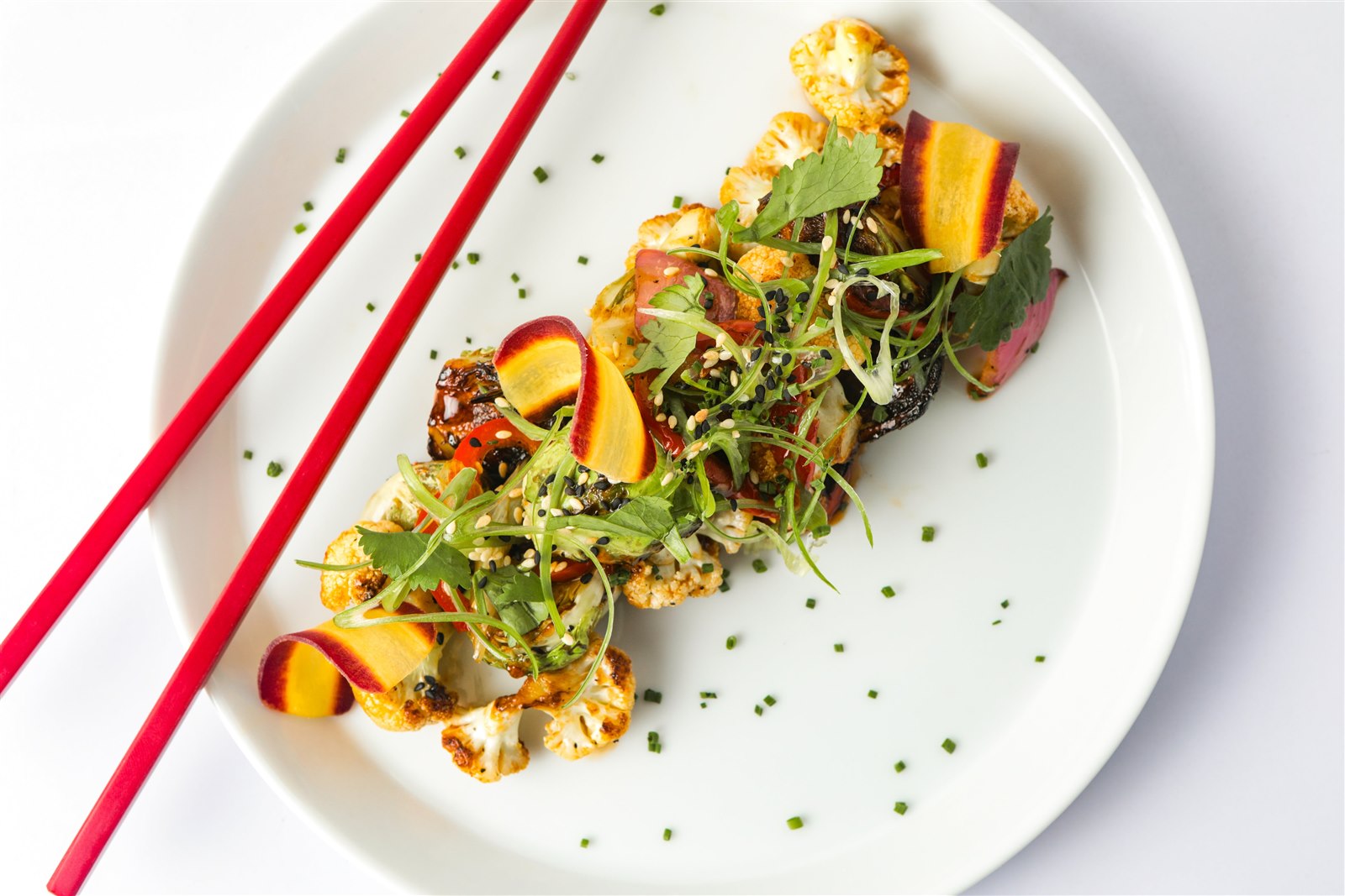 A colourful plated dish garnished with fresh greens